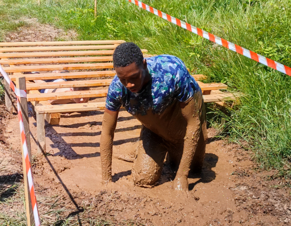 Un jeune franchit un obstacle de boue lors de la Funny Run organisée par l'IME du Val d'Ajol