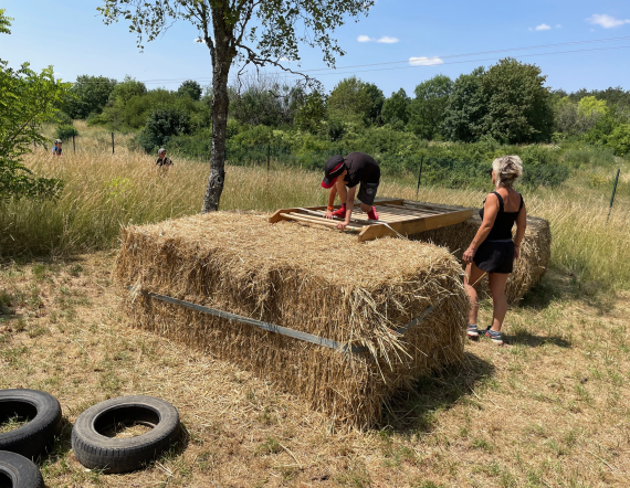 Un jeune sur un obstacle de paille lors de l'événement la Ruée des P'tits Suizes