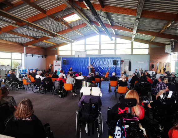 Les patients de Lay-Saint-Christophe en train de regarder le concert du duo RASKOVNIK dans le gymnase de l'établissement