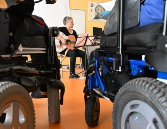 Photo de notre atelier musical. Avec au centre de la photo, notre intervenante et chanteuse: Lady Arlette, entourée de nos patients.