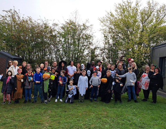 Un groupe d'enfants et d'adultes posent pour la photo lors de la fête d'Halloween.