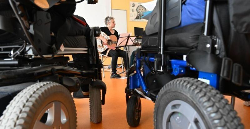 Photo de notre atelier musical. Avec au centre de la photo, notre intervenante et chanteuse: Lady Arlette, entourée de nos patients.