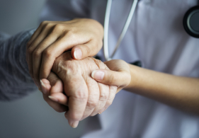 Mains de soutien d'un soignant à une personne âgée