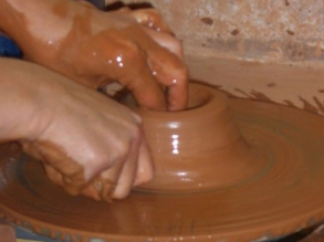 Gros plan sur des mains sur un tour de potier dans l'atelier poterie de l'IME A. Dedecker